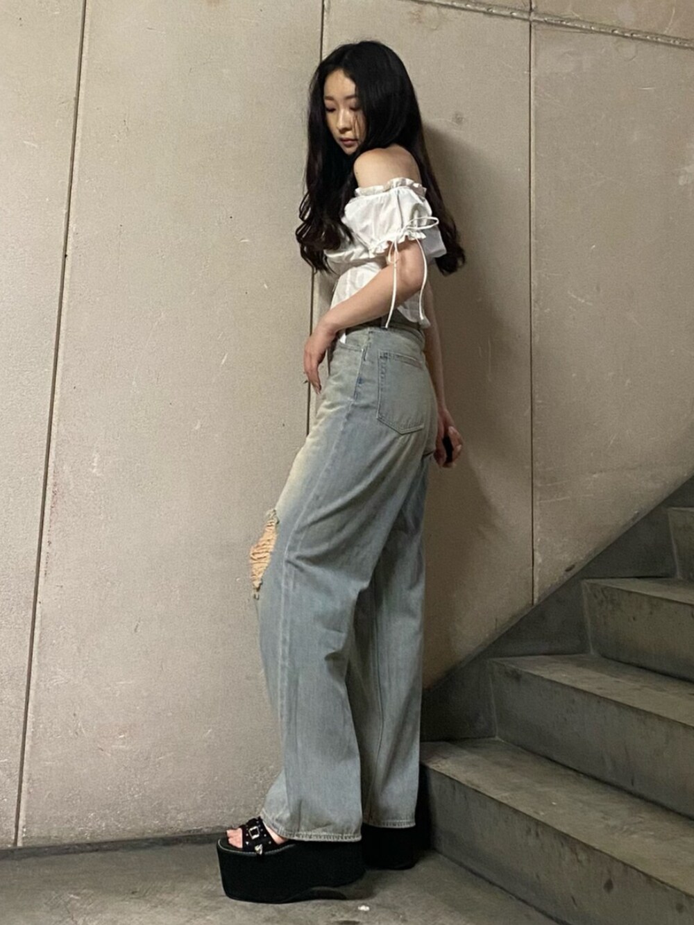 ブルー系のデニムパンツ、ブラック系のサンダル、ホワイト系のシャツ/ブラウスを着用したレディースの夏コーディネートの2枚目の写真