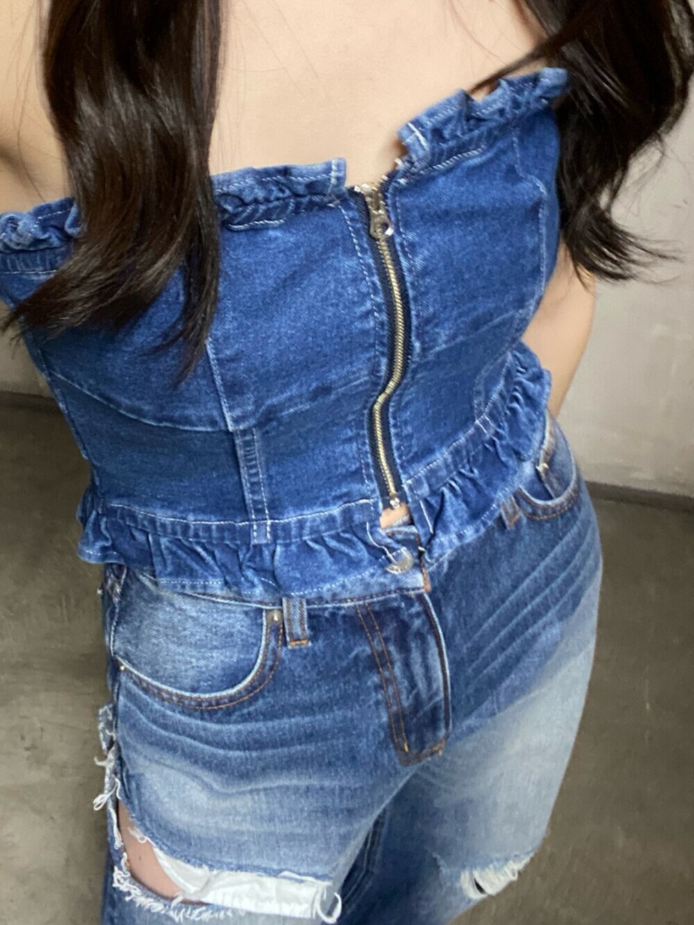 ブルー系のチューブトップ、ブルー系のデニムパンツを着用したレディースの冬コーディネートの4枚目の写真