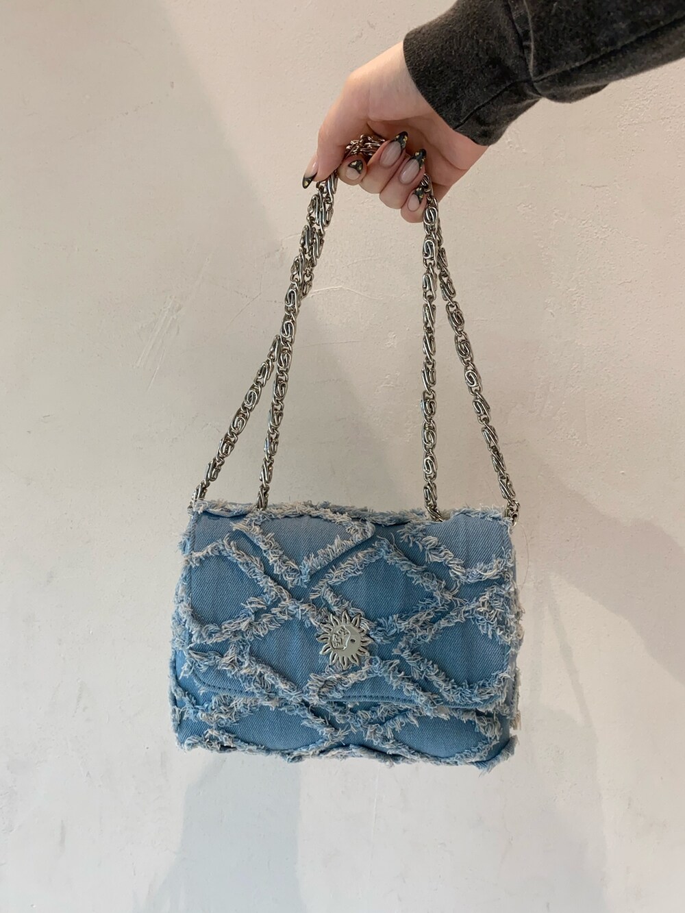 グレー系のTシャツ/カットソー、ブラック系のスカート、ブルー系のショルダーバッグを着用したレディースの冬コーディネートの8枚目の写真