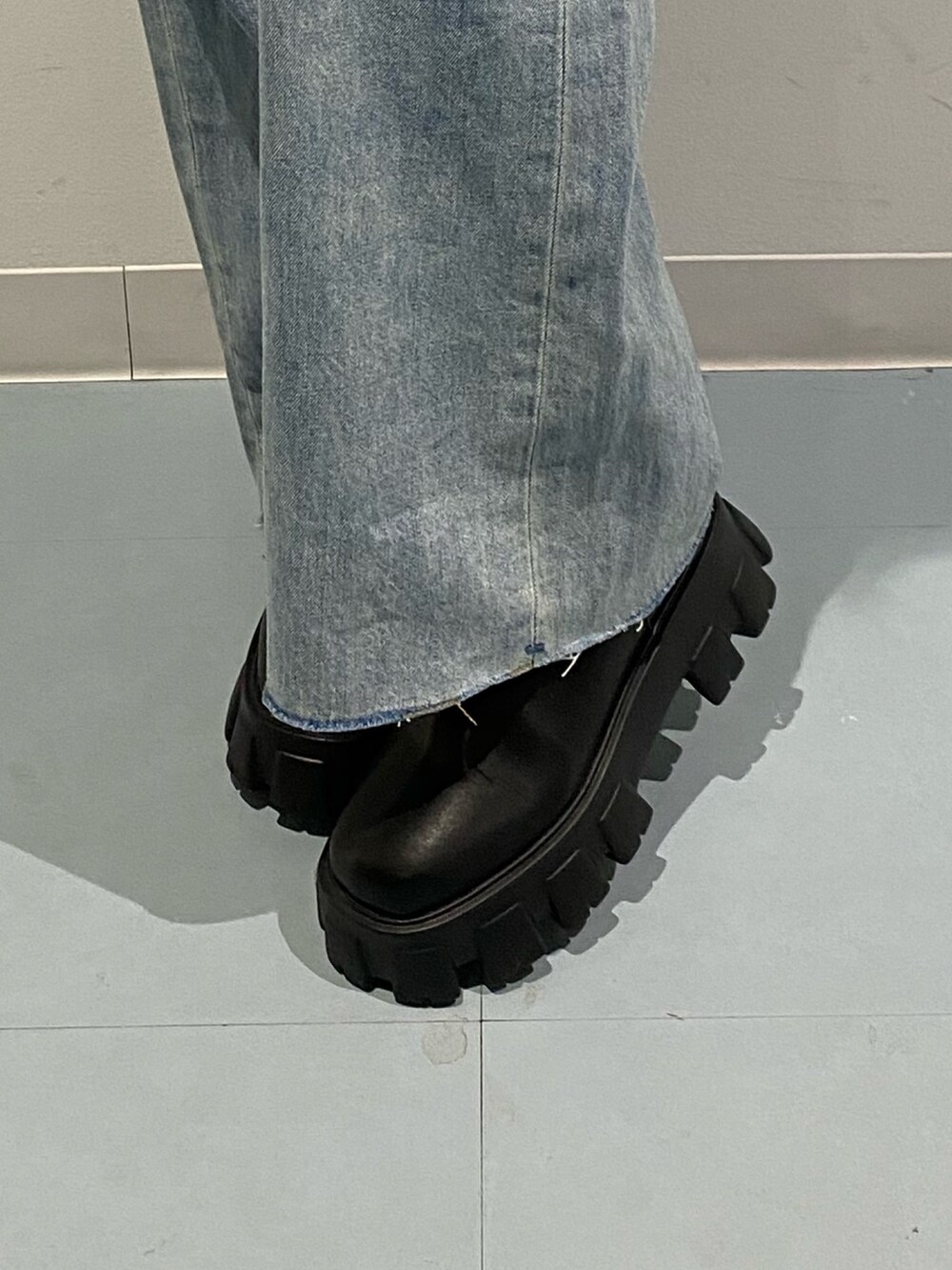 ブラック系のブルゾン、ブラック系のブーツ、ブルー系のデニムパンツを着用したレディースの秋コーディネートの6枚目の写真