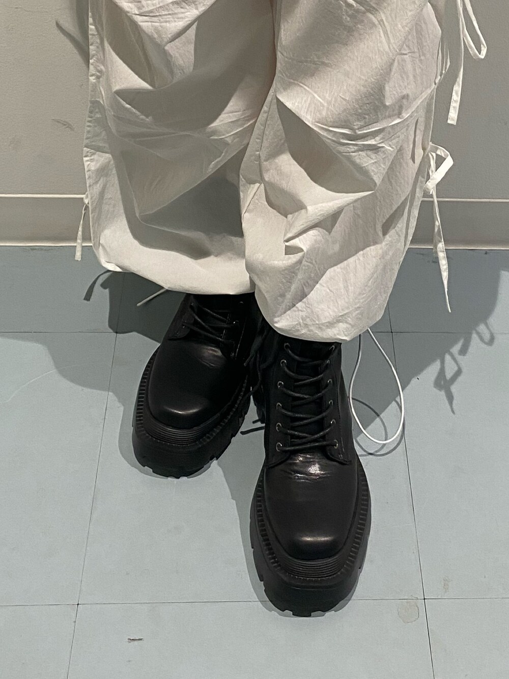 ブラック系のニット/セーター、ホワイト系のその他パンツ、ブラック系のブーツを着用したレディースの夏コーディネートの7枚目の写真