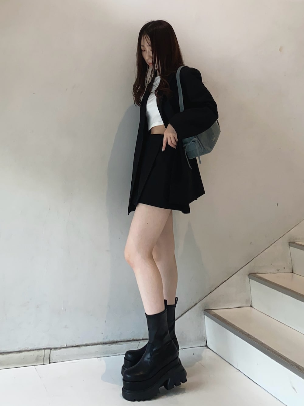 ブラック系のテーラードジャケット、ブラック系のスカート、ホワイト系のTシャツ/カットソーを着用したレディースの秋コーディネートの2枚目の写真