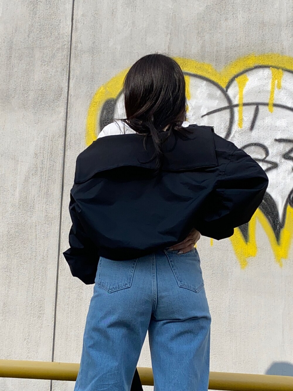 ブラック系のMA-1、ブルー系のデニムパンツ、ホワイト系のTシャツ/カットソーを着用したレディースの春コーディネートの5枚目の写真