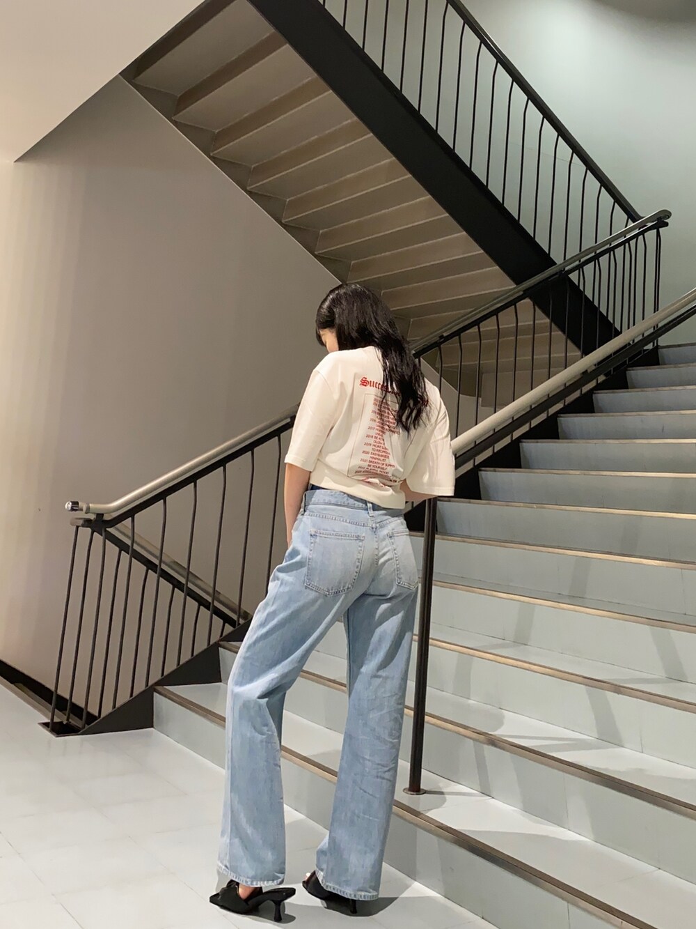 ホワイト系のTシャツ/カットソー、ブルー系のデニムパンツ、ブラック系のサンダルを着用したレディースの夏コーディネートの2枚目の写真