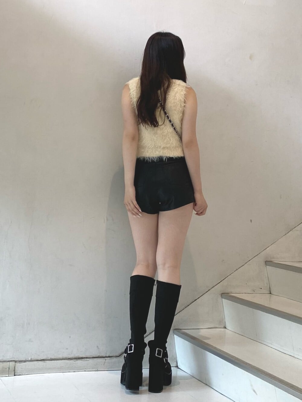 ホワイト系のタンクトップ、ブラック系のその他パンツ、ブラック系のブーツを着用したレディースの秋コーディネートの3枚目の写真