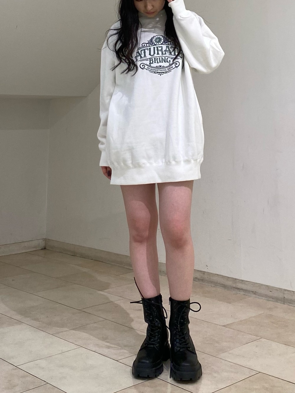 ホワイト系のスウェット、ブラック系のその他パンツ、ブラック系のブーツを着用したレディースの秋コーディネートの3枚目の写真