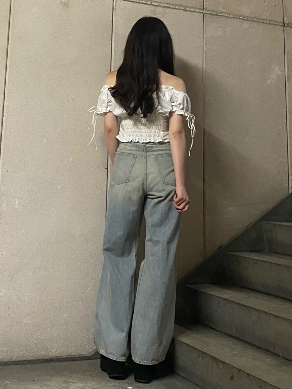 ブルー系のデニムパンツ、ブラック系のサンダル、ホワイト系のシャツ/ブラウスを着用したレディースの夏コーディネートの3枚目の写真