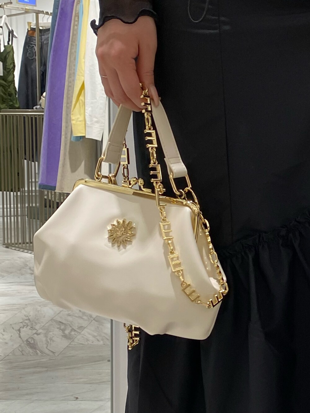 ブラック系のブーツ、ホワイト系のショルダーバッグ、ブラック系のワンピースを着用したレディースの冬コーディネートの4枚目の写真