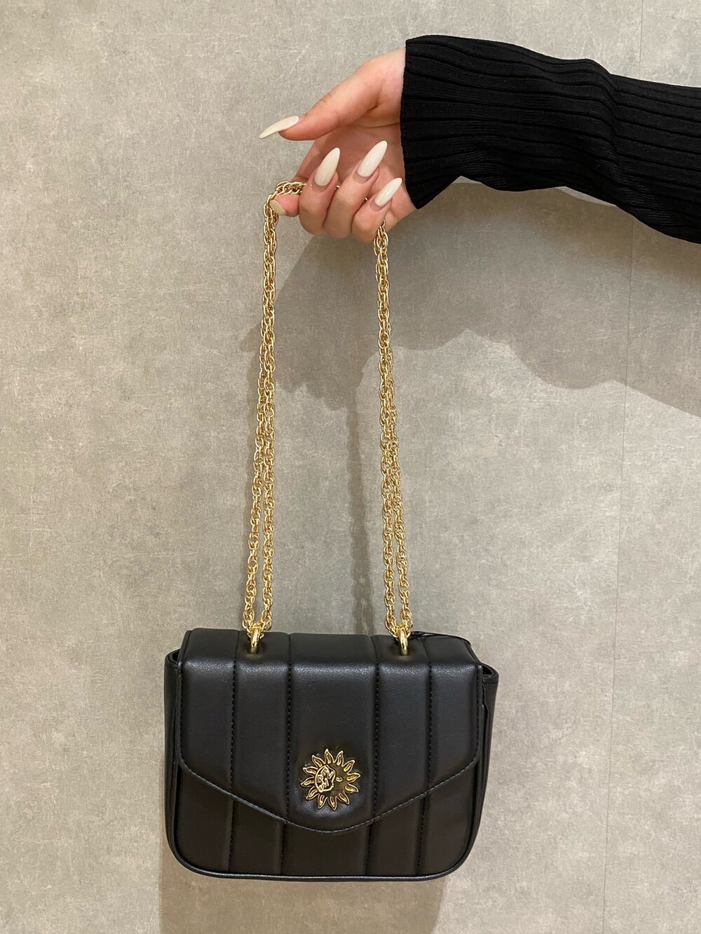 ブラック系のカーディガン/ボレロ、ブルー系のデニムパンツ、ブラック系のブーツを着用したレディースの秋コーディネートの7枚目の写真