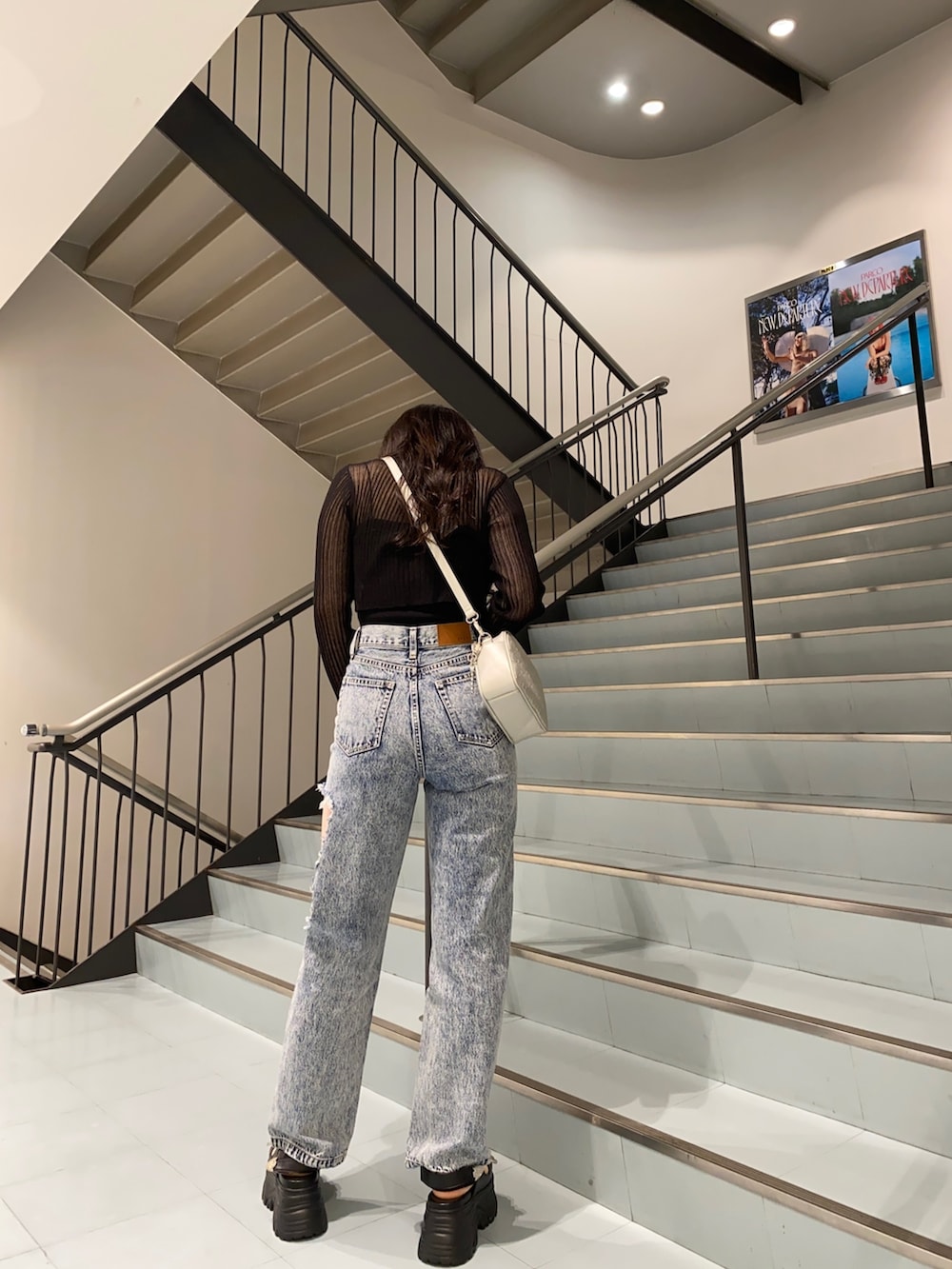 ブラック系のカーディガン/ボレロ、ブルー系のデニムパンツ、ブラック系のサンダルを着用したレディースの春コーディネートの2枚目の写真