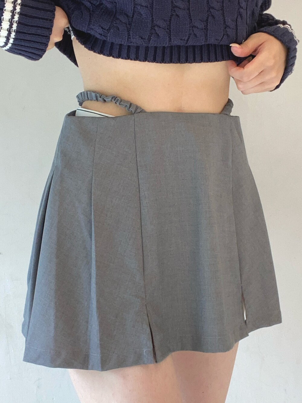 グレー系のスカート、ブルー系のニット/セーター、ブラック系のショルダーバッグを着用したレディースの夏コーディネートの5枚目の写真