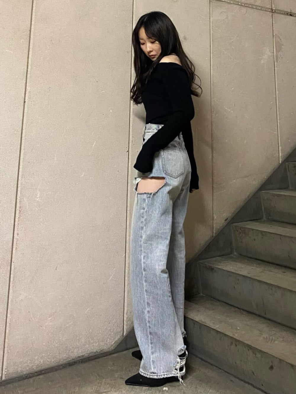 ブラック系のサンダル、ブラック系のニット/セーター、ブルー系のデニムパンツを着用したレディースの春コーディネートの2枚目の写真