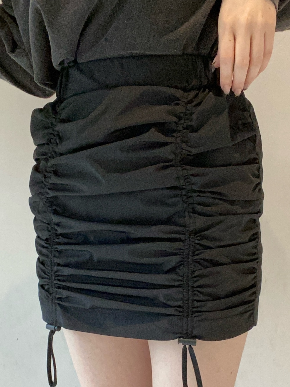 グレー系のTシャツ/カットソー、ブラック系のスカート、ブルー系のショルダーバッグを着用したレディースの冬コーディネートの6枚目の写真