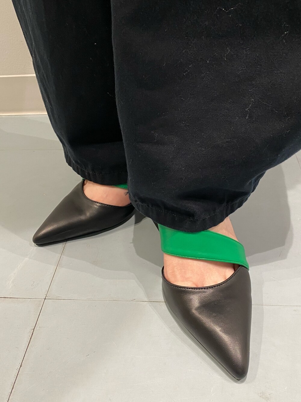 グリーン系のニット/セーター、ブラック系のサンダル、シルバー系のショルダーバッグを着用したレディースの春コーディネートの5枚目の写真