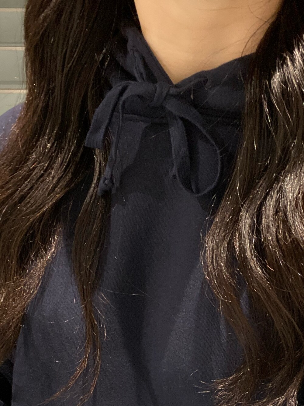 ブルー系のパーカー、ブラック系のブーツ、ブラック系のショルダーバッグを着用したレディースの秋コーディネートの4枚目の写真