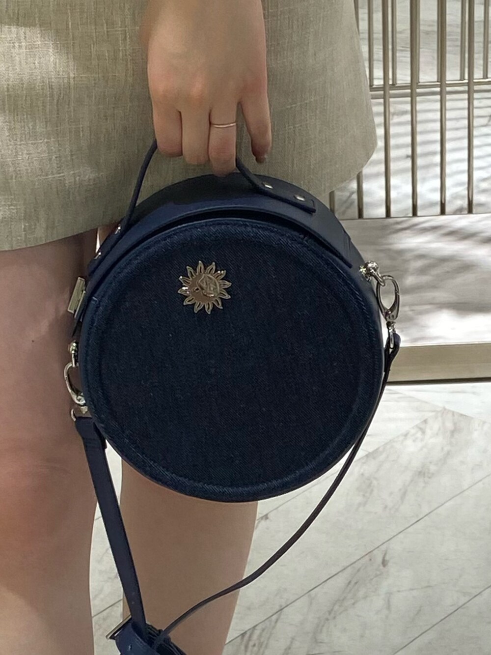 ホワイト系のテーラードジャケット、ホワイト系のスカート、ブラック系のサンダルを着用したレディースの春コーディネートの7枚目の写真