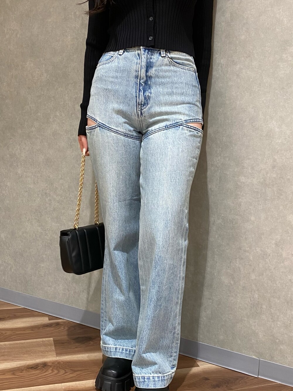 ブラック系のカーディガン/ボレロ、ブルー系のデニムパンツ、ブラック系のブーツを着用したレディースの秋コーディネートの3枚目の写真