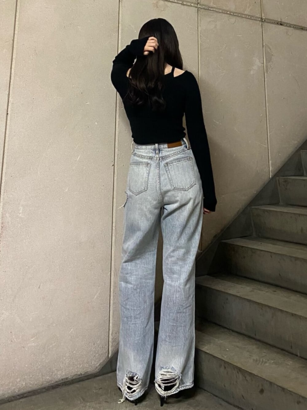 ブラック系のサンダル、ブラック系のニット/セーター、ブルー系のデニムパンツを着用したレディースの春コーディネートの3枚目の写真