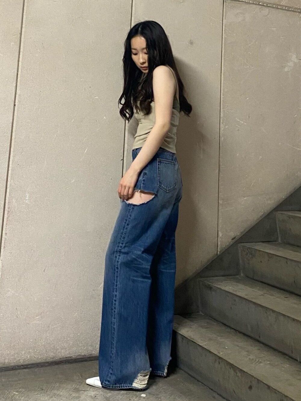 ブルー系のデニムパンツ、ホワイト系のパンプス、ベージュ系のタンクトップを着用したレディースの春コーディネートの2枚目の写真