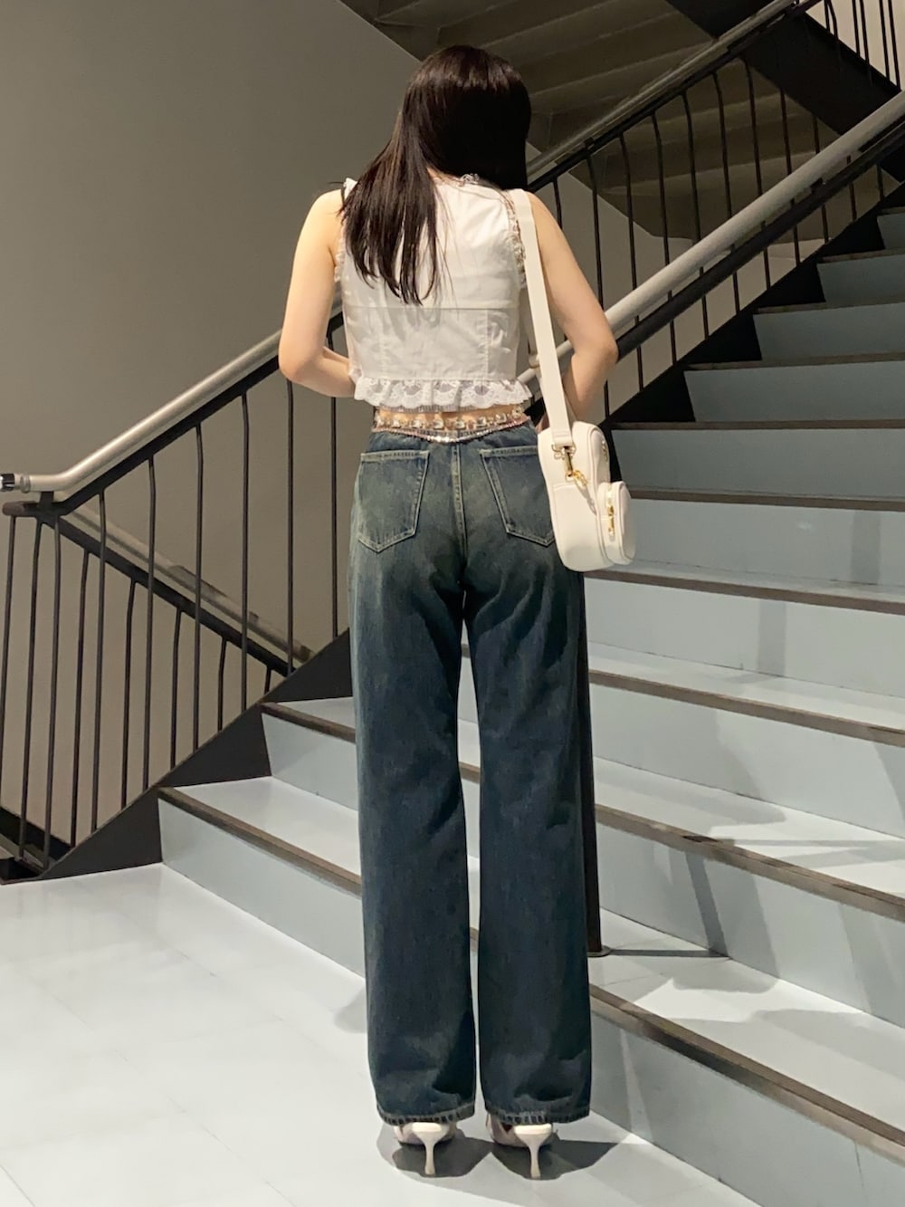 ブルー系のデニムパンツ、ホワイト系のサンダル、ホワイト系のシャツ/ブラウスを着用したレディースの夏コーディネートの3枚目の写真