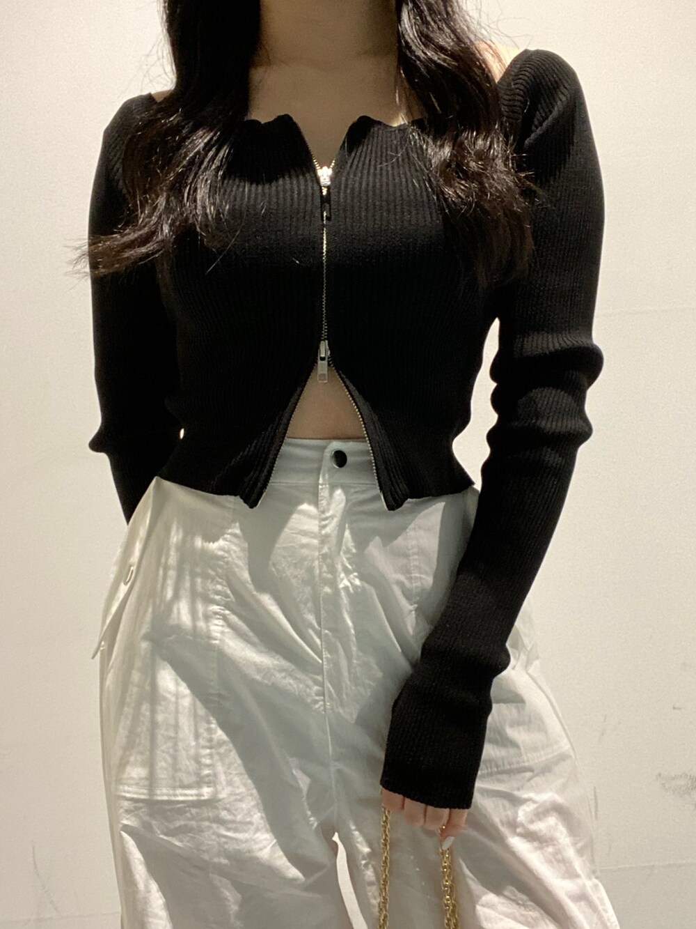 ブラック系のニット/セーター、ホワイト系のその他パンツ、ブラック系のブーツを着用したレディースの夏コーディネートの3枚目の写真