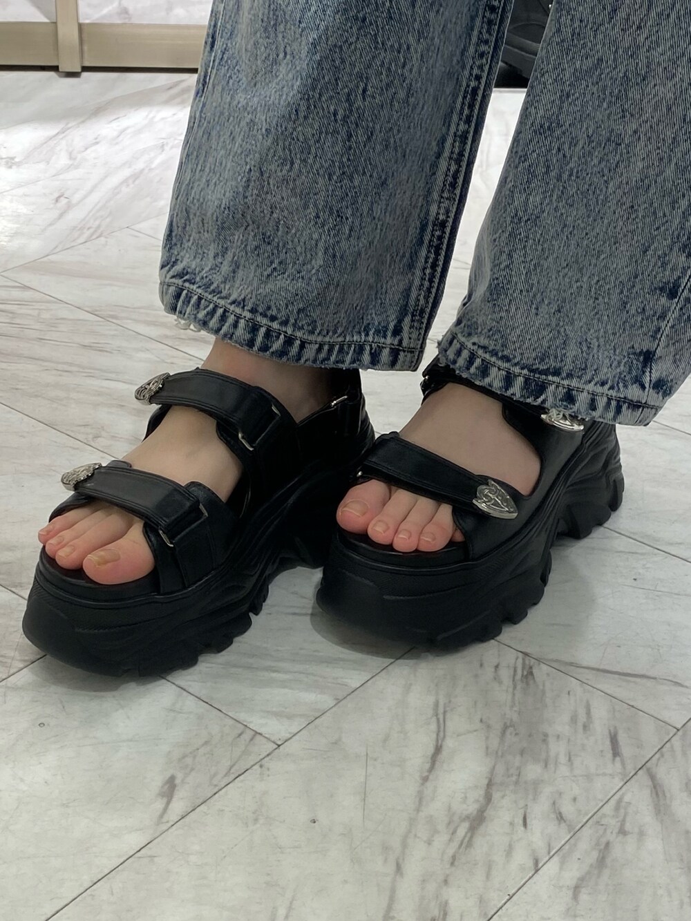 ブラック系のカーディガン/ボレロ、ブルー系のデニムパンツ、ブラック系のサンダルを着用したレディースの春コーディネートの7枚目の写真