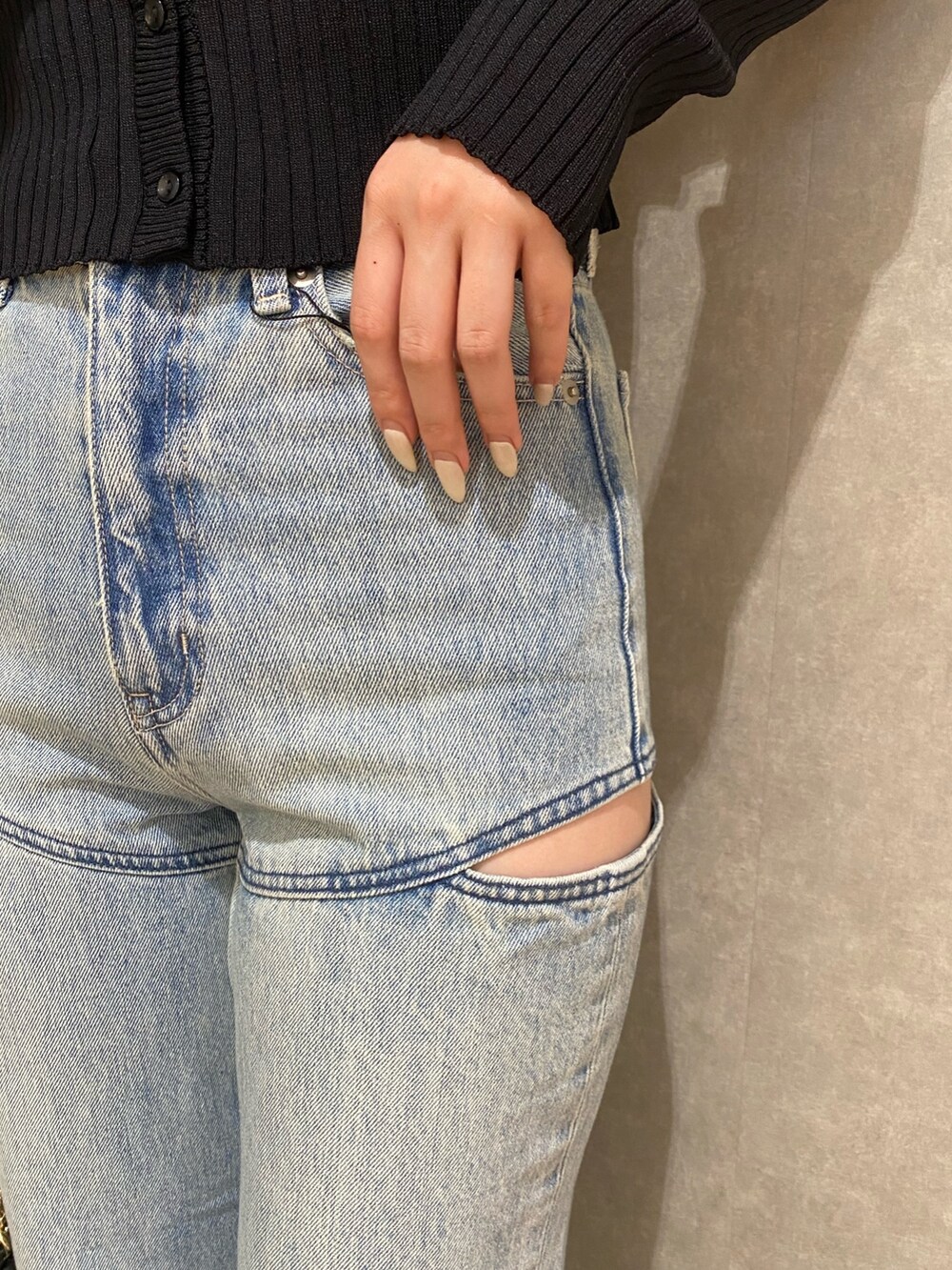 ブラック系のカーディガン/ボレロ、ブルー系のデニムパンツ、ブラック系のブーツを着用したレディースの秋コーディネートの5枚目の写真