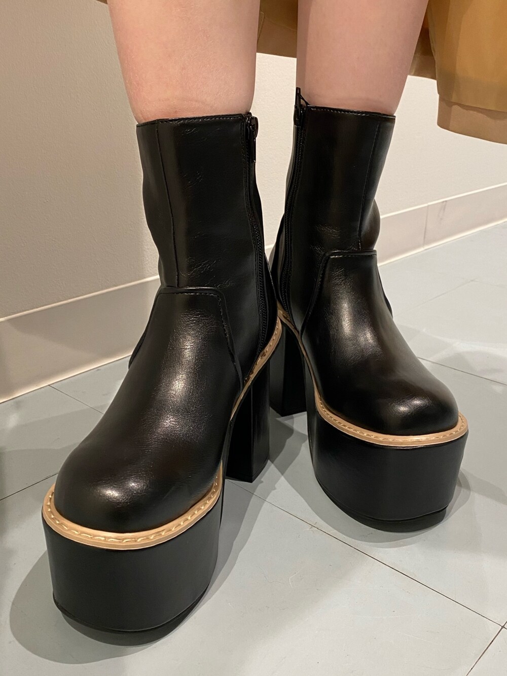 ブラック系のブーツ、ホワイト系のショルダーバッグ、ブラック系のワンピースを着用したレディースの冬コーディネートの5枚目の写真