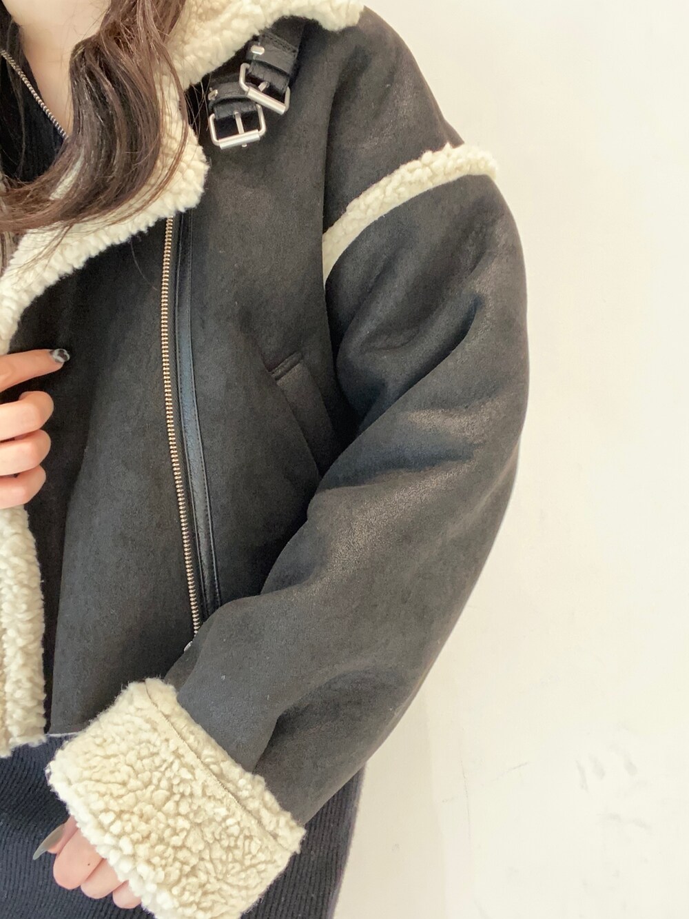 ブラック系のムートンコート、ブラック系のワンピース、ブラック系のハンドバッグを着用したレディースの秋コーディネートの4枚目の写真