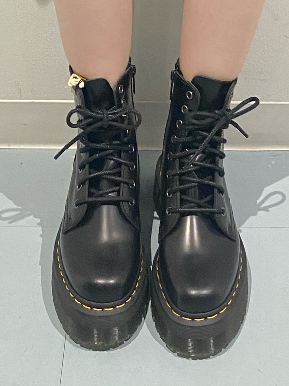 ブルー系のパーカー、ブラック系のブーツ、ブラック系のショルダーバッグを着用したレディースの秋コーディネートの6枚目の写真