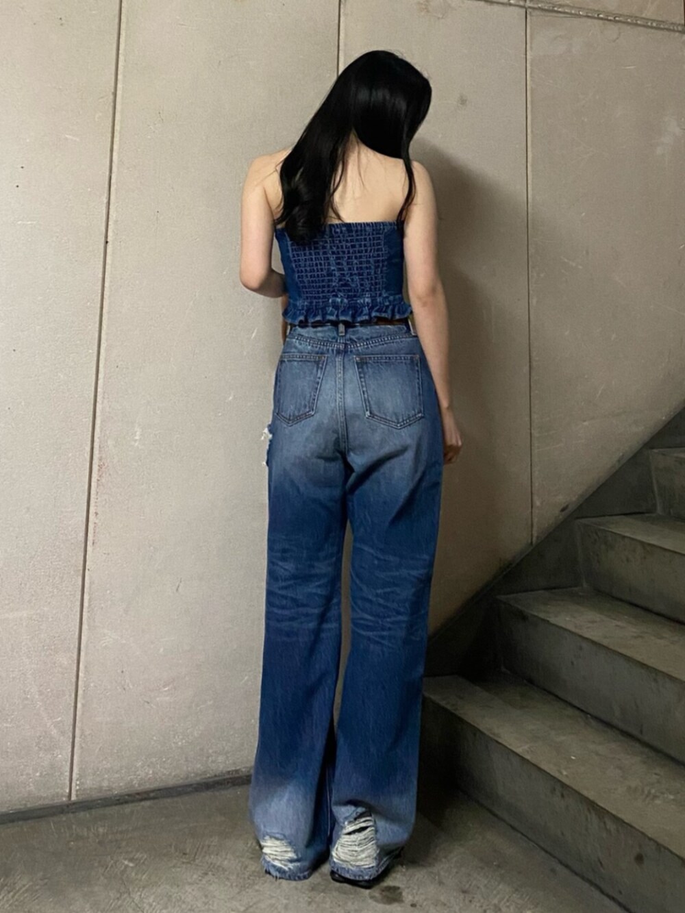 ブルー系のチューブトップ、ブルー系のデニムパンツを着用したレディースの冬コーディネートの3枚目の写真