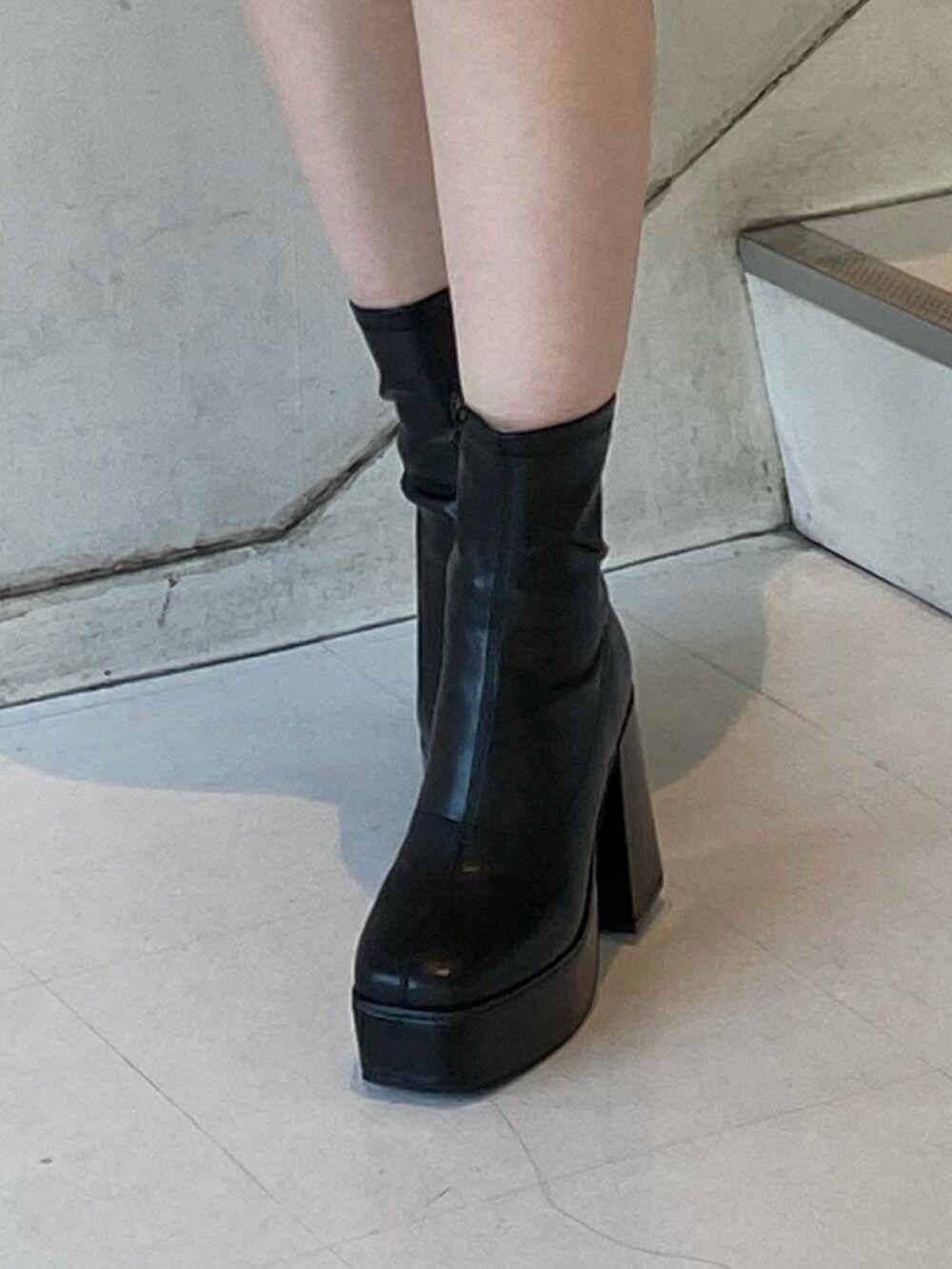 ブラック系のワンピース、ブラック系のブーツ、ブラック系のショルダーバッグを着用したレディースの秋コーディネートの6枚目の写真