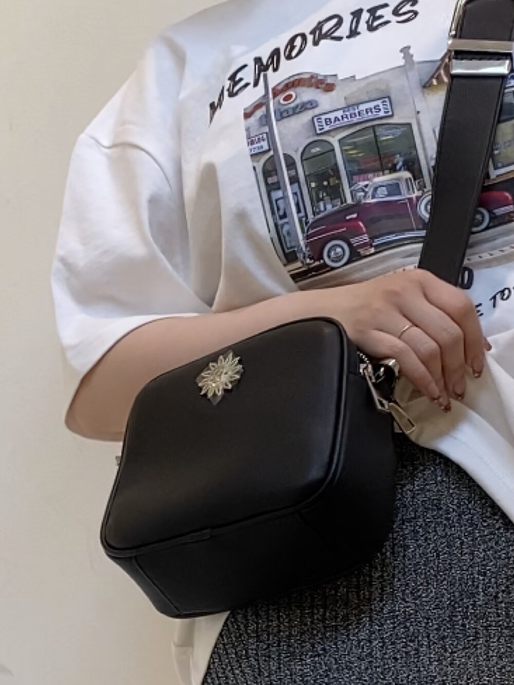 ホワイト系のTシャツ/カットソー、ブラック系のショルダーバッグ、ブラック系のワンピースを着用したレディースの春コーディネートの6枚目の写真