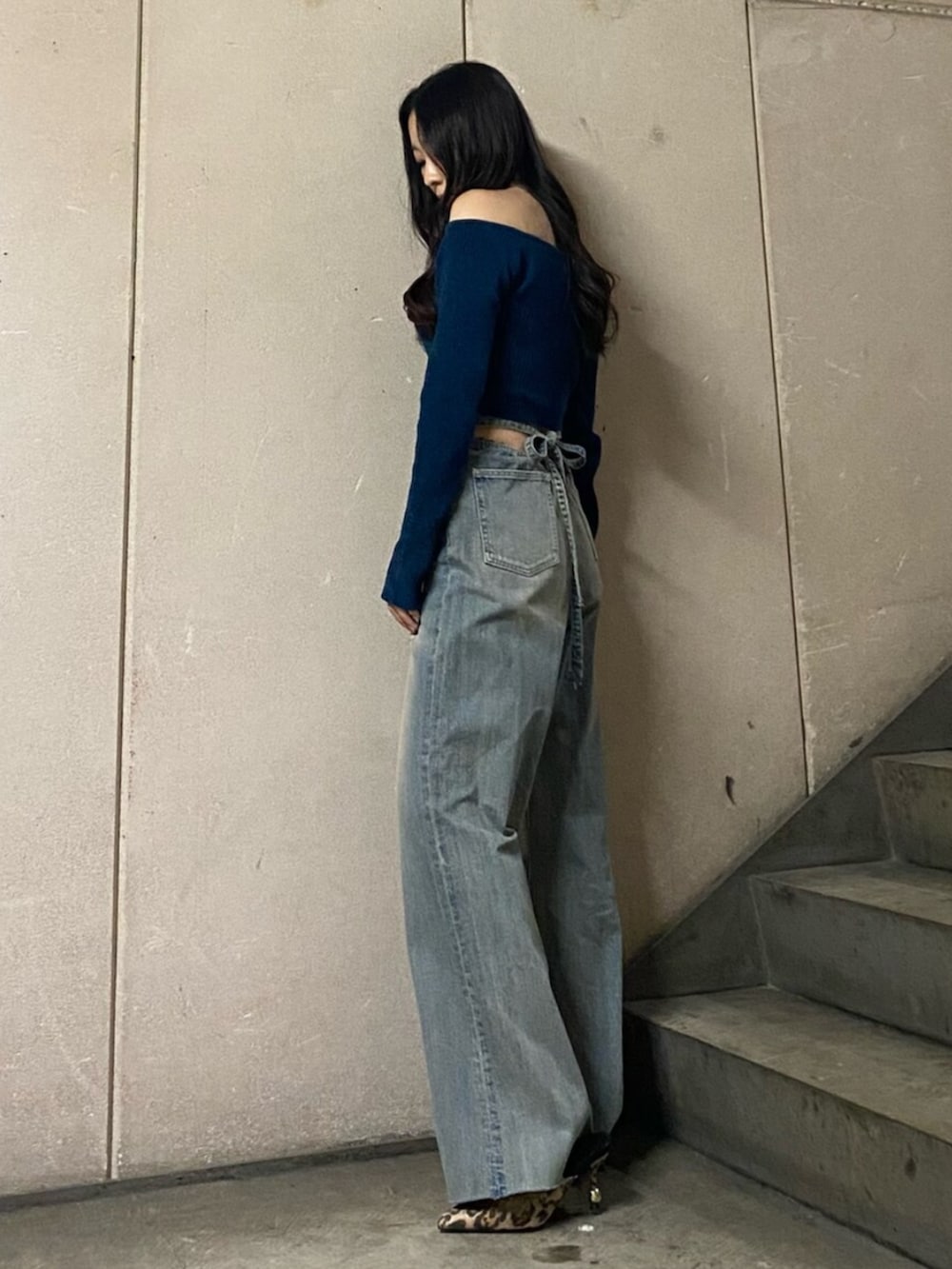 ブルー系のニット/セーター、ブルー系のデニムパンツ、その他のサンダルを着用したレディースの秋コーディネートの2枚目の写真