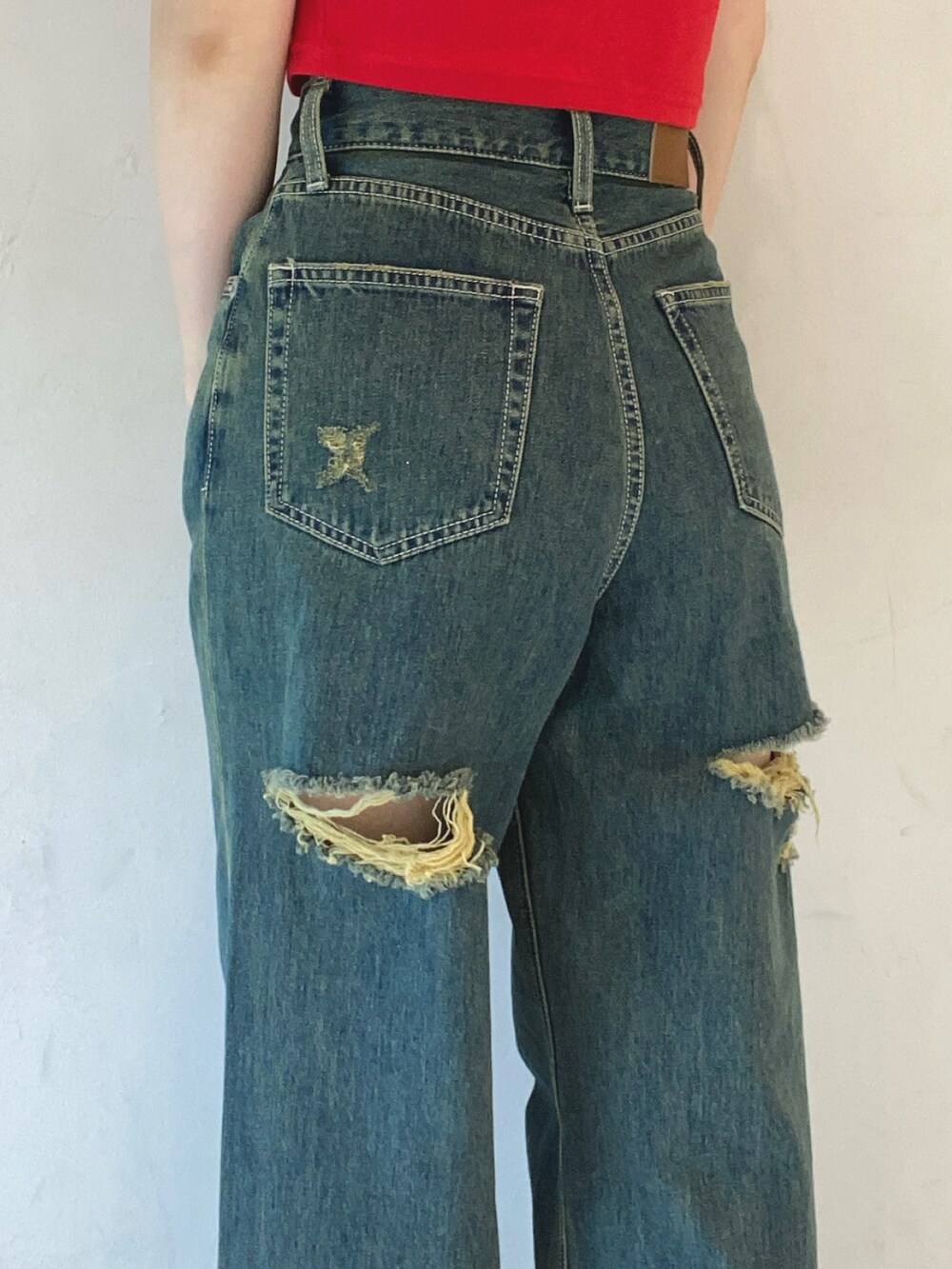 レッド系のTシャツ/カットソー、ブルー系のデニムパンツ、ホワイト系のサンダルを着用したレディースの夏コーディネートの5枚目の写真