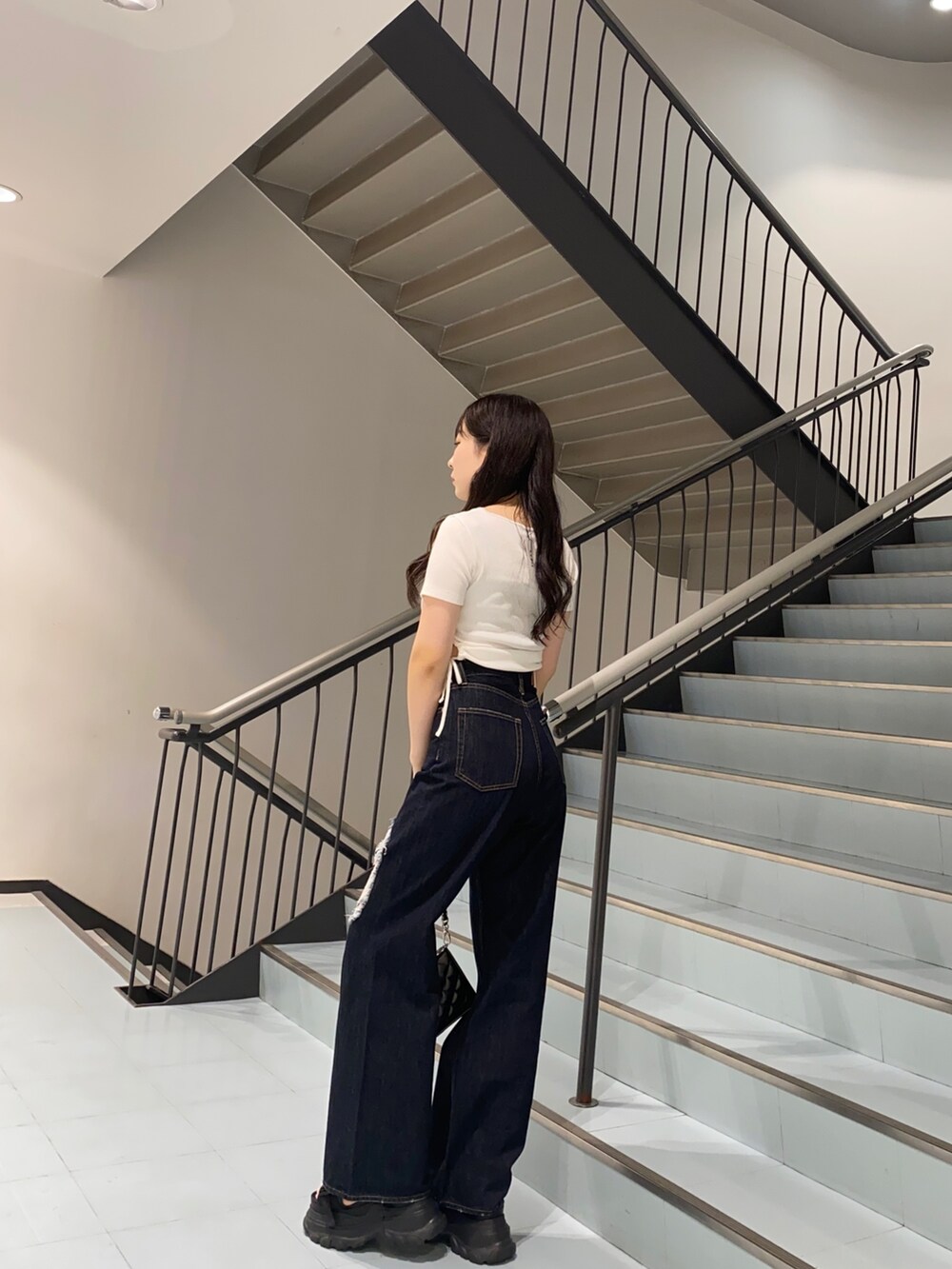 ホワイト系のTシャツ/カットソー、ブラック系のショルダーバッグ、ブルー系のデニムパンツを着用したレディースの夏コーディネートの2枚目の写真