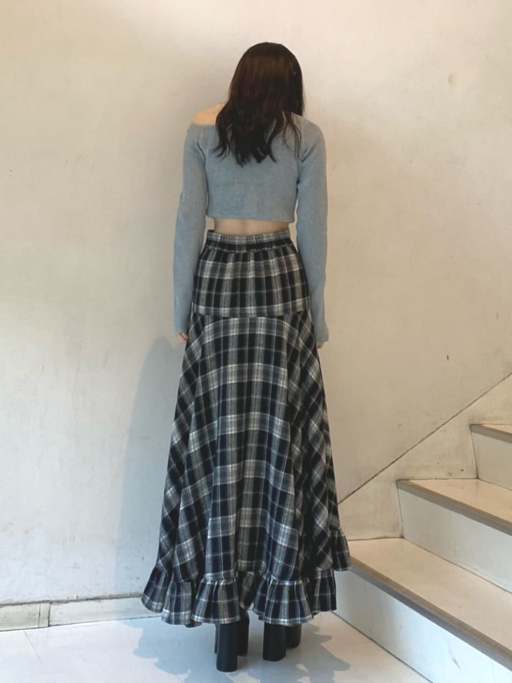 グレー系のニット/セーター、ブラック系のスカート、ブラック系のブーツを着用したレディースの冬コーディネートの3枚目の写真