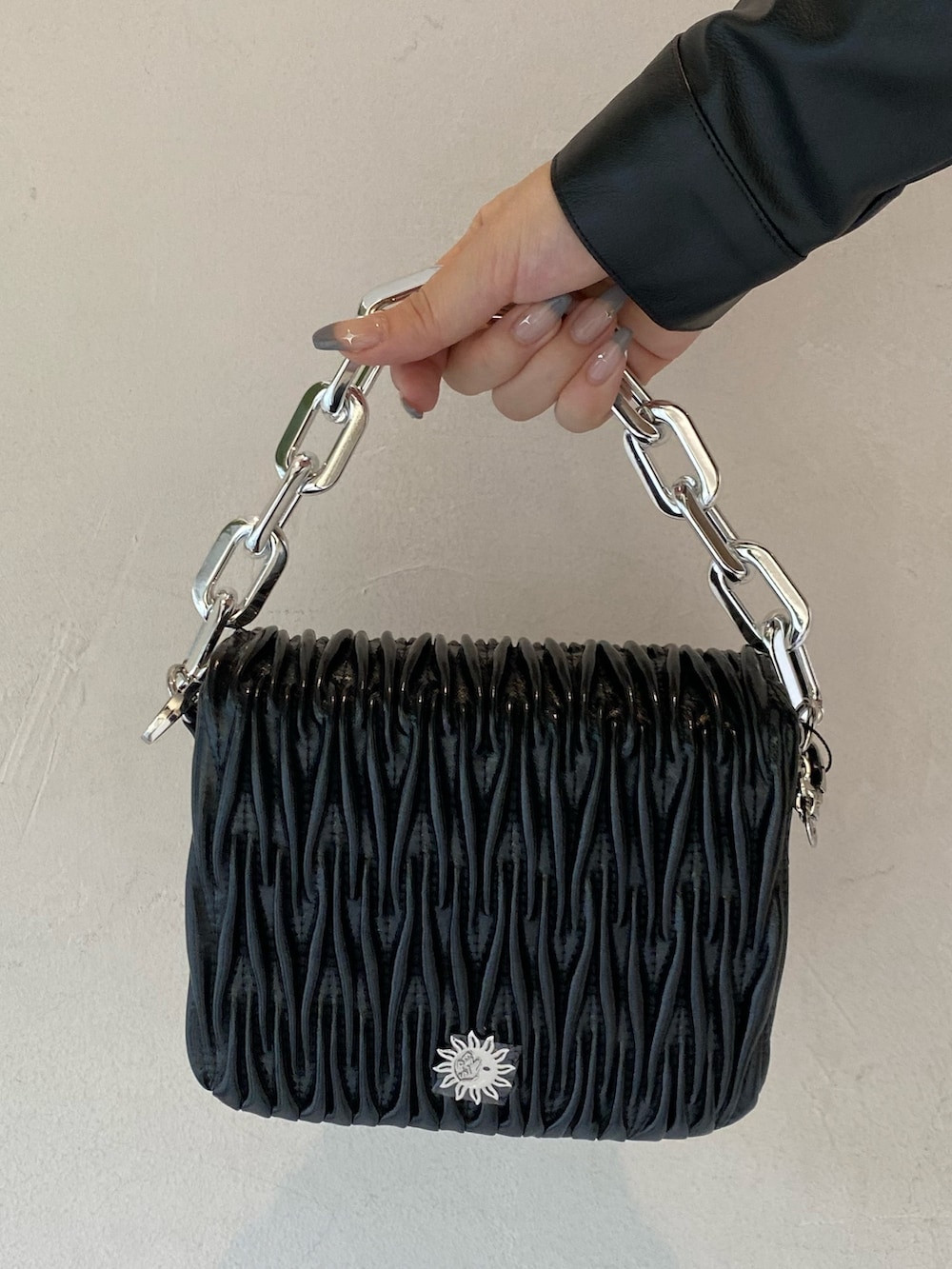 ブラック系のワンピース、ブラック系のブーツ、ブラック系のショルダーバッグを着用したレディースの秋コーディネートの5枚目の写真