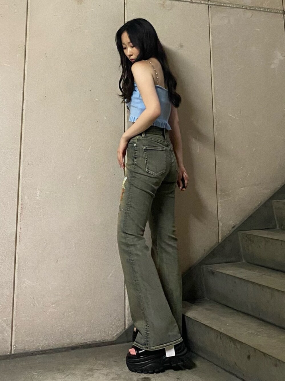 ブルー系のキャミソール、ブルー系のデニムパンツ、ブラック系のサンダルを着用したレディースの夏コーディネートの2枚目の写真