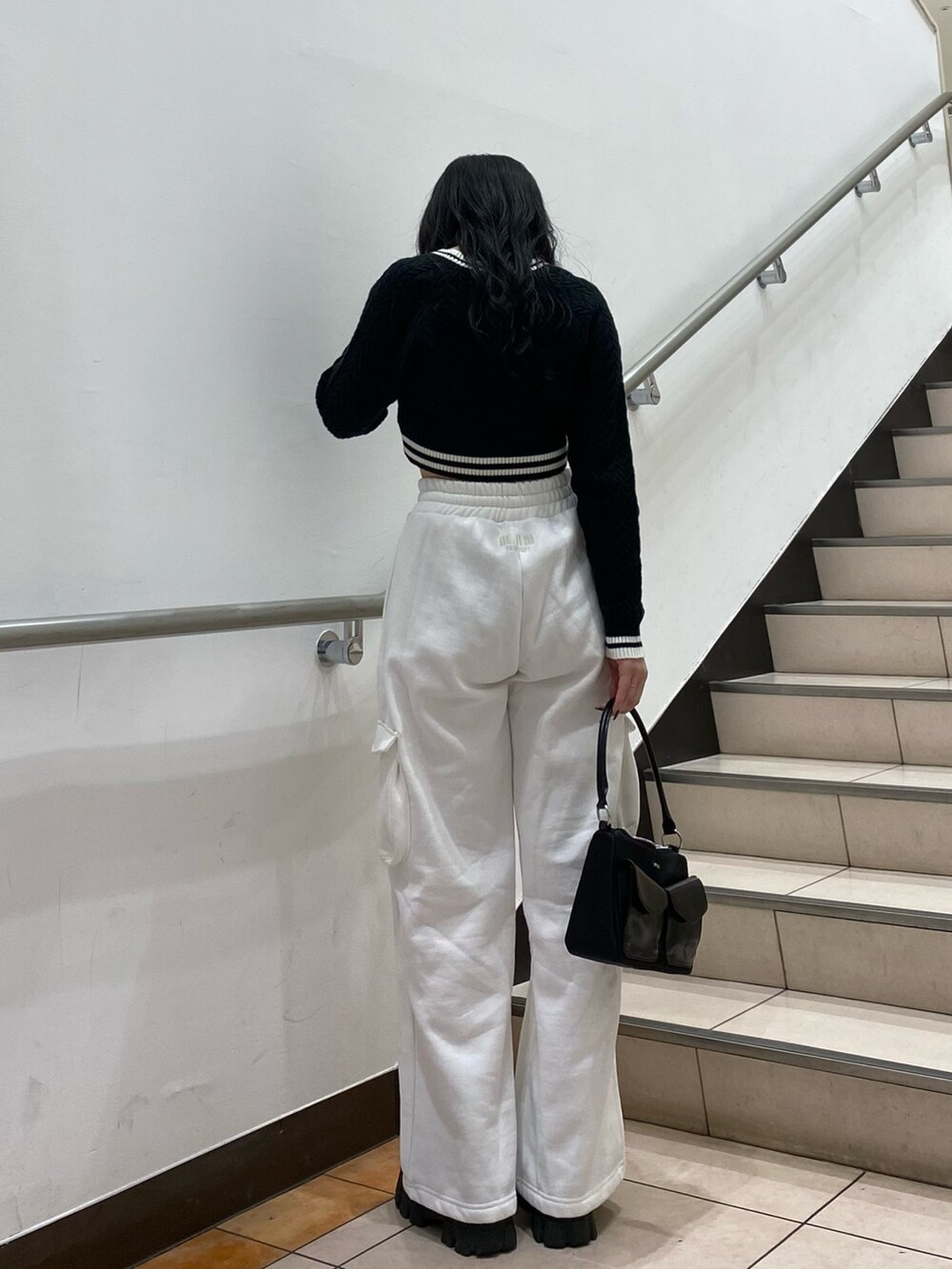 ブラック系のニット/セーター、ホワイト系のスウェットパンツ、ブラック系のハンドバッグを着用したレディースの秋コーディネートの2枚目の写真