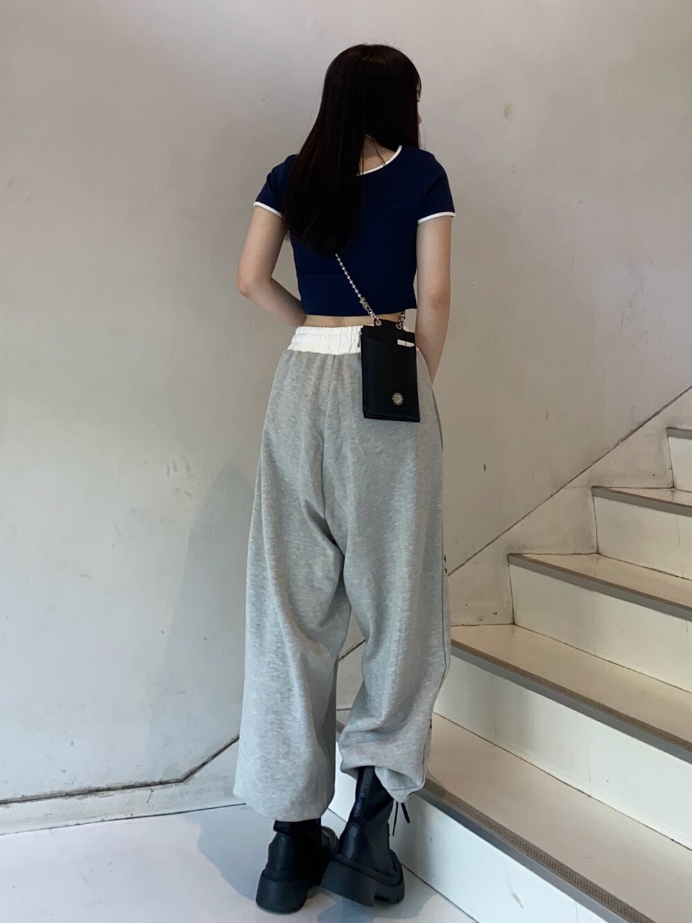 ブルー系のTシャツ/カットソー、グレー系のスウェットパンツ、ブラック系のショルダーバッグを着用したレディースの夏コーディネートの3枚目の写真