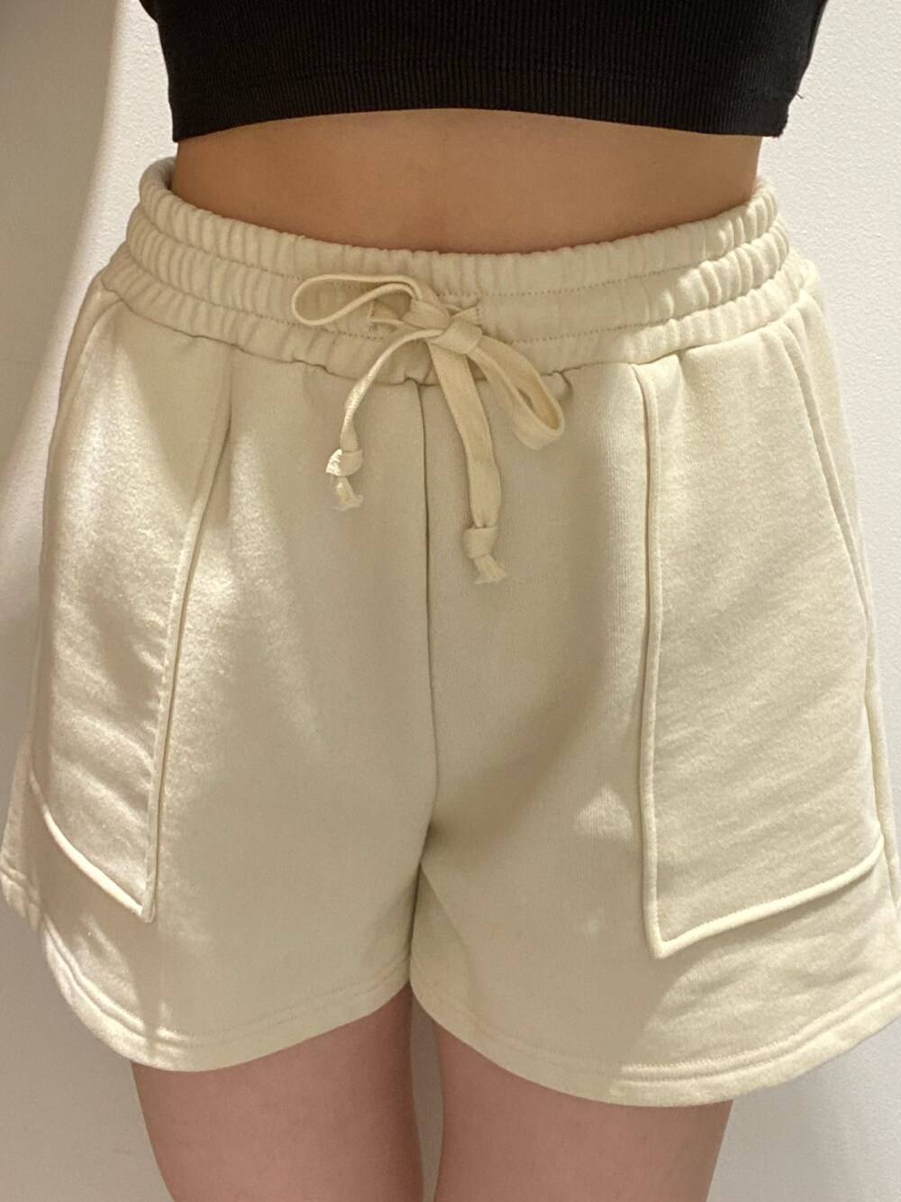 ホワイト系のスウェット、ブラック系のショルダーバッグ、ブラック系のブーツを着用したレディースの冬コーディネートの4枚目の写真