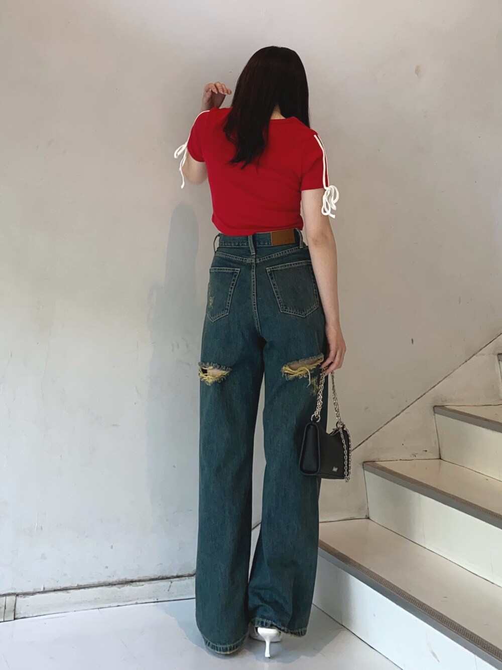 レッド系のTシャツ/カットソー、ブルー系のデニムパンツ、ホワイト系のサンダルを着用したレディースの夏コーディネートの3枚目の写真