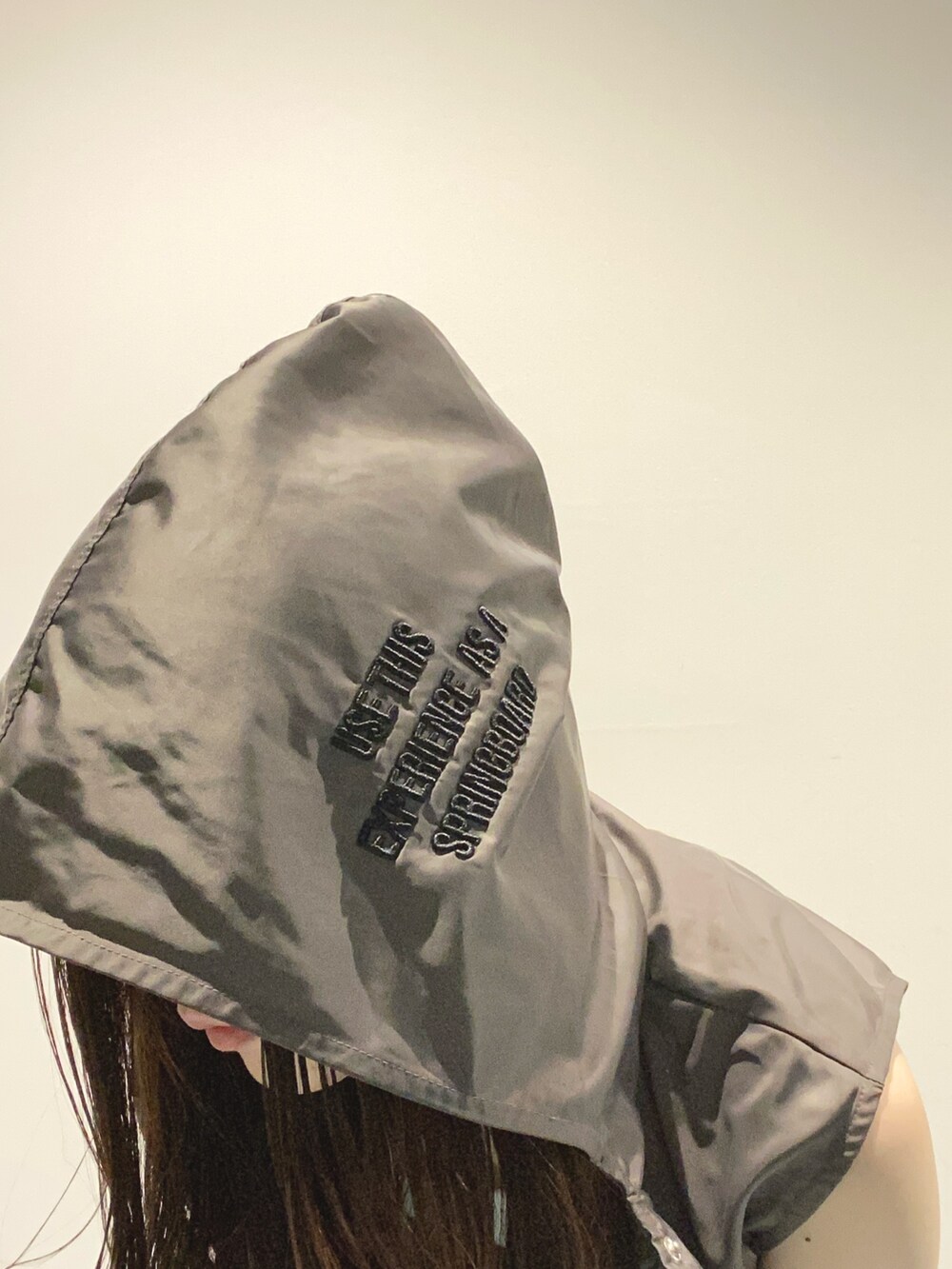 グレー系のベスト、グレー系のスカート、ブラック系のショルダーバッグを着用したレディースの夏コーディネートの5枚目の写真