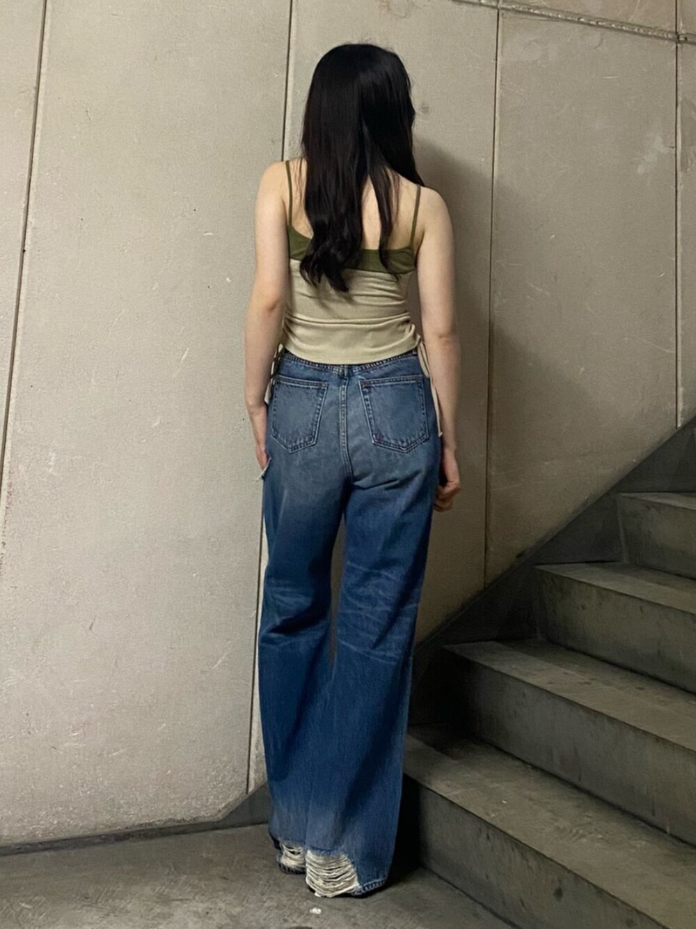 ブルー系のデニムパンツ、ホワイト系のパンプス、ベージュ系のタンクトップを着用したレディースの春コーディネートの3枚目の写真