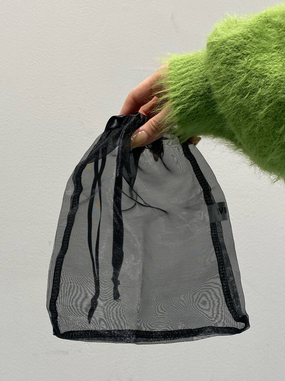 グリーン系のニット/セーター、ブルー系のデニムスカート、ブラック系のブーツを着用したレディースの冬コーディネートの7枚目の写真