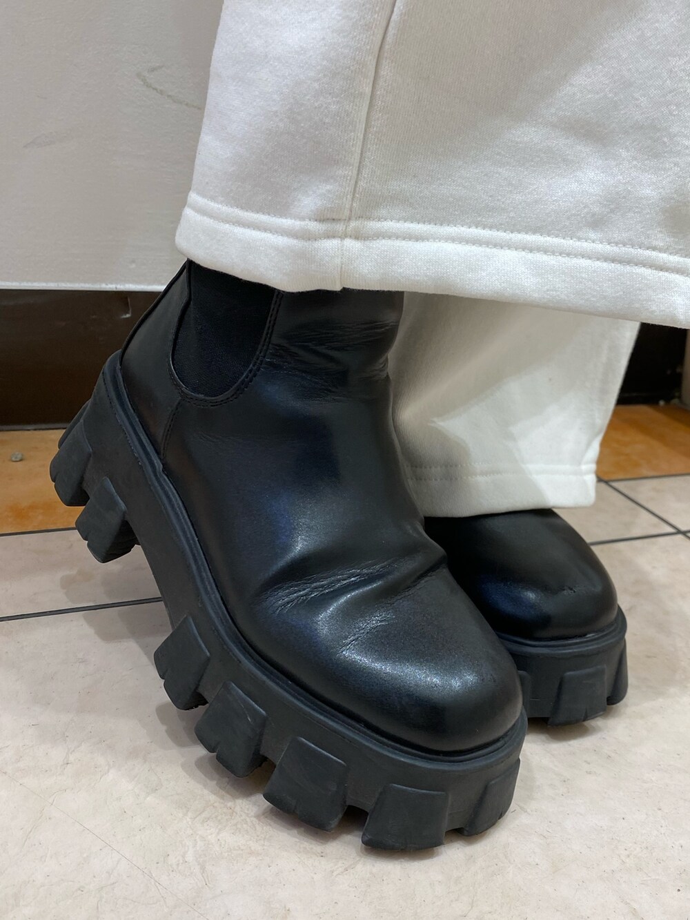 ブラック系のニット/セーター、ホワイト系のスウェットパンツ、ブラック系のハンドバッグを着用したレディースの秋コーディネートの5枚目の写真