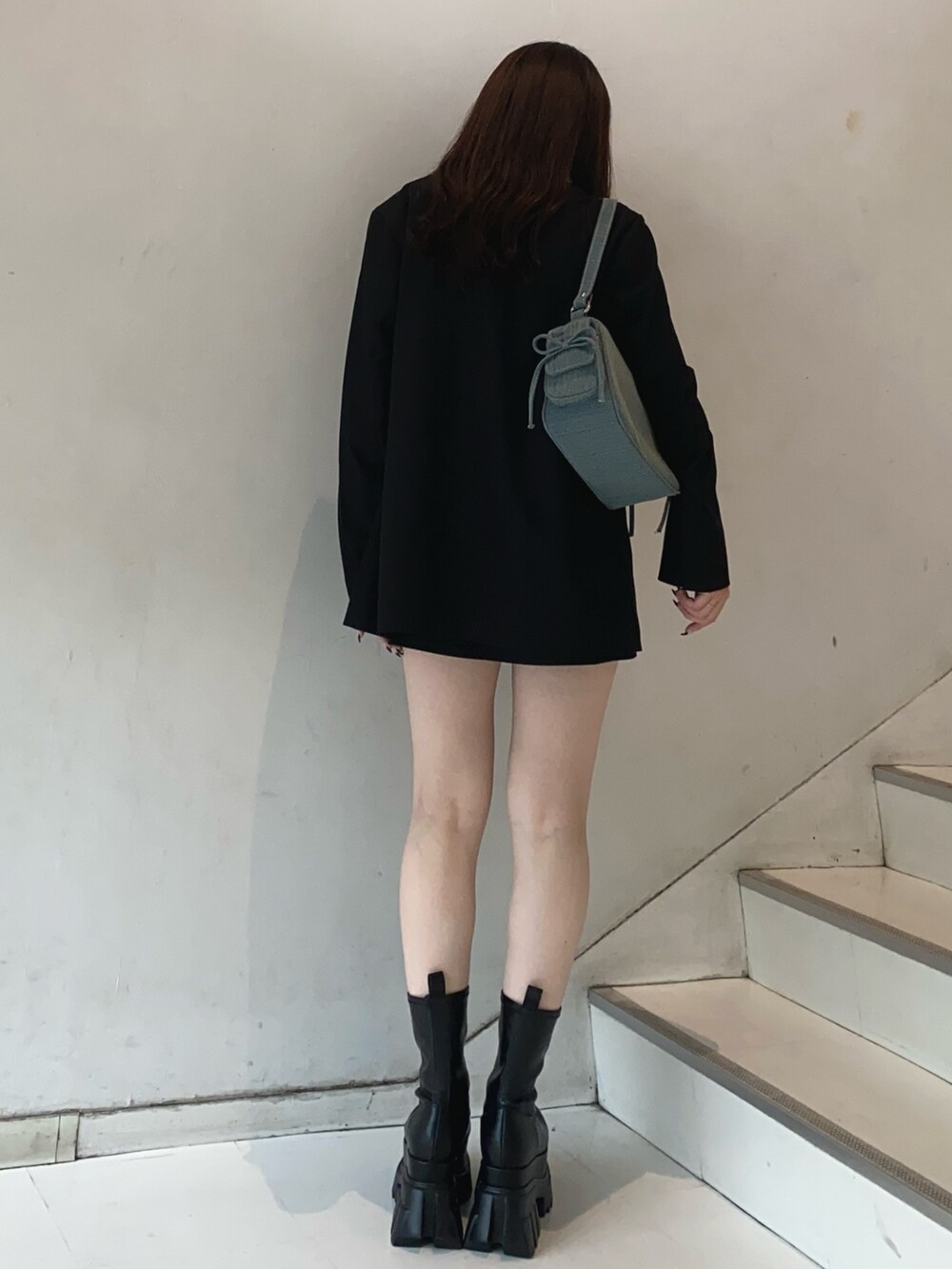 ブラック系のテーラードジャケット、ブラック系のスカート、ホワイト系のTシャツ/カットソーを着用したレディースの秋コーディネートの3枚目の写真