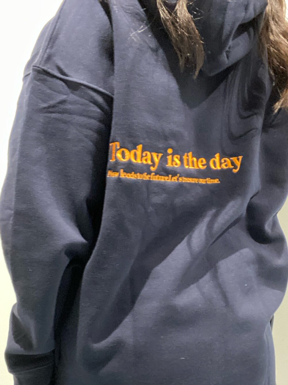 ブルー系のパーカー、ブラック系のブーツ、ブラック系のショルダーバッグを着用したレディースの秋コーディネートの3枚目の写真