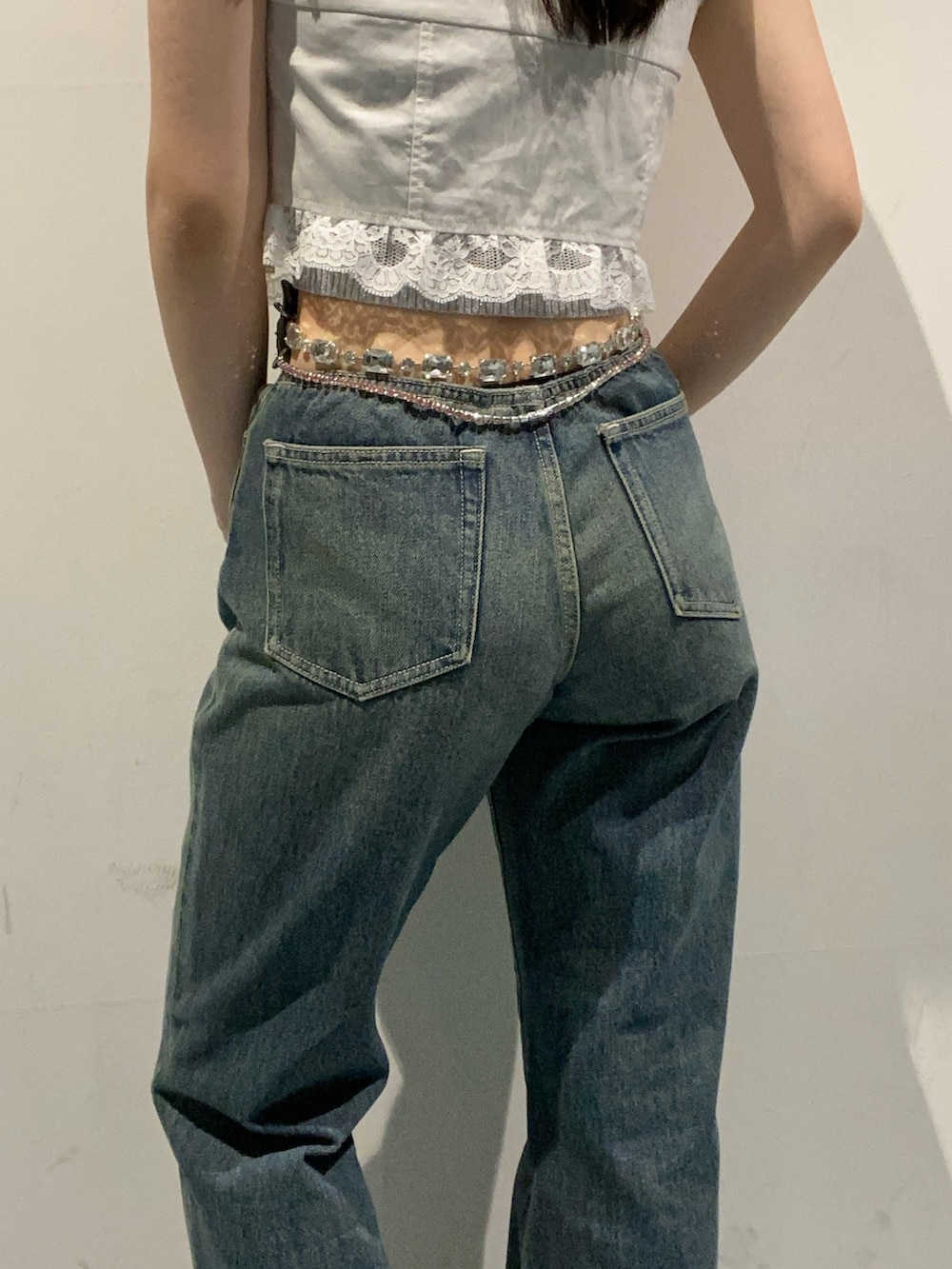 ブルー系のデニムパンツ、ホワイト系のサンダル、ホワイト系のシャツ/ブラウスを着用したレディースの夏コーディネートの5枚目の写真